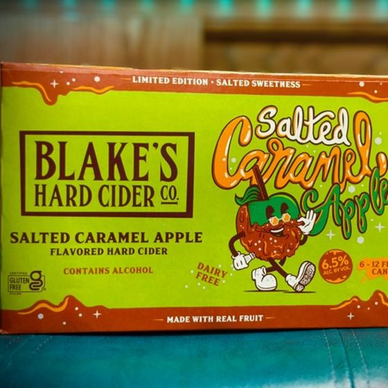 A six pack box of Blake's Hard Cider Salted Caramel Apple, bright green with a cartoon caramel apple character